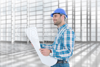 Composite image of smiling engineer looking away while holding b