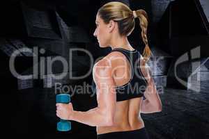 Composite image of female bodybuilder holding a blue dumbbell