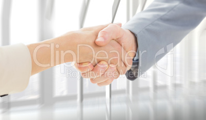 Composite image of closeup of shaking hands after business meeti