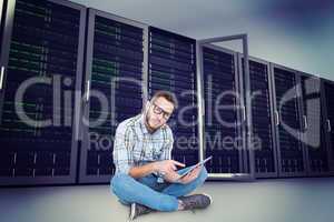 Composite image of handsome hipster using tablet pc