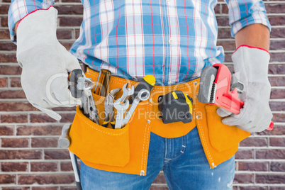 Composite image of midsection of handyman holding hand tools