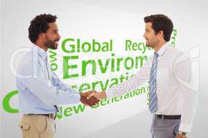 Composite image of smiling young businessmen shaking hands in of