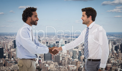 Composite image of smiling young businessmen shaking hands in of