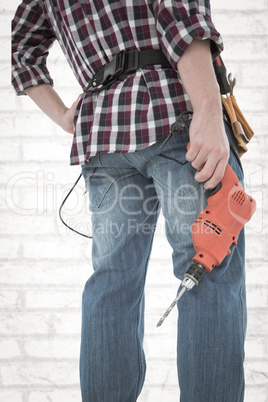 Composite image of male handyman holding drill machine