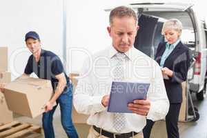 Focused manager holding tablet in front of his colleagues