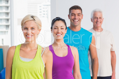Cheerful women and men in sports wear at gym