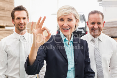 Smiling warehouse manager making okay gesture