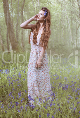 Artistic portrait of a girl in a bluebell forest