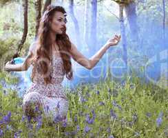 Artistic portrait of a girl in a bluebell forest