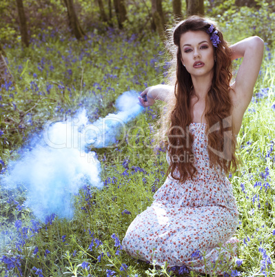 Artistic portrait of a girl in a bluebell forest