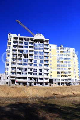 modern skyscraper with hoisting crane