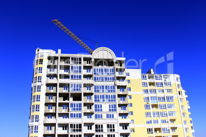 modern skyscraper with hoisting crane