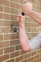 Man hitting a brick wall with a hammer