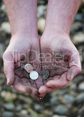 Dirty cupped hands holding few coins