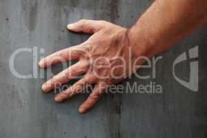 Male hand touching the surface of a concrete wall