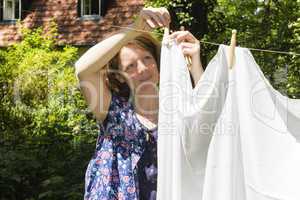 Frau beim Wäscheaufhängen im Garten, Hanging up the washing in