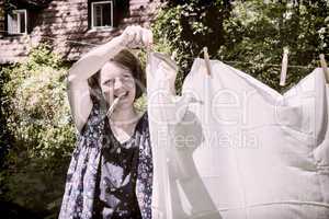 Frau beim Wäscheaufhängen im Garten, Hanging up the washing