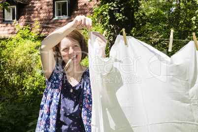 Frau beim Wäscheaufhängen im Garten, Hanging up the washing in
