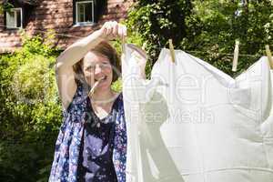 Frau beim Wäscheaufhängen im Garten, Hanging up the washing in