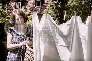 Frau beim Wäscheaufhängen im Garten, Hanging up the washing