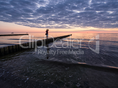 Fotograf auf einer Buhne an der Ostseeküste