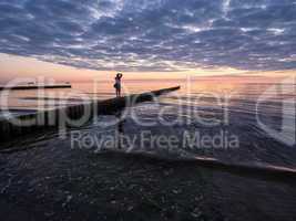 Fotograf auf einer Buhne an der Ostseeküste