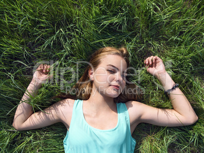 sensual young blonde lying on the grass outdoors