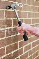 Man hitting a brick wall with a hammer