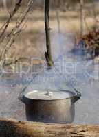 Cooking in sooty cauldron on campfire