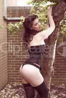 Woman in Black Corset Posing Outdoors Against Tree