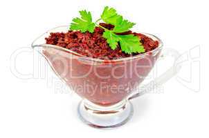 Adjika in glass gravy boat with parsley