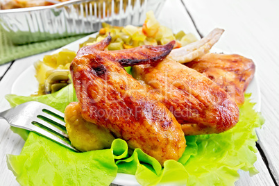 Chicken wings fried with salad in plate on board