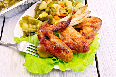 Chicken wings fried with vegetables and salad in plate