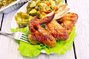 Chicken wings fried with vegetables and salad in plate