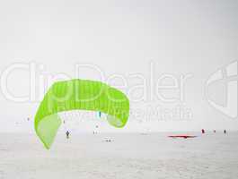 Kiteboarder with kite on the snow