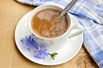 Chicory drink in white cup with spoon on board