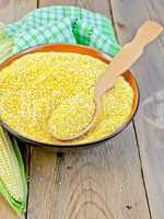 Corn grits with cob and spoon on board