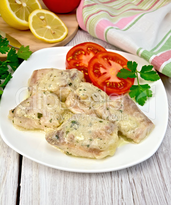 Fish stew in sauce on plate with lemon