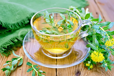 Herbal tea in cup with Rhodiola rosea and napkin on board