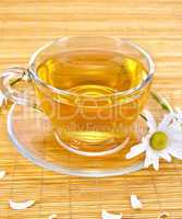 Herbal tea with camomiles on bamboo napkin