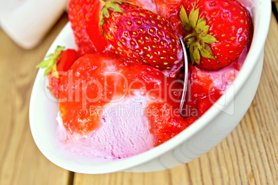 Ice cream strawberry in bowl with spoon on board