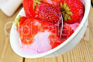 Ice cream strawberry in bowl with spoon on board