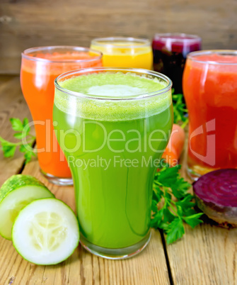Juice cucumber and vegetable in glassful with parsley on board