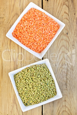 Lentils red and green in white bowls on board