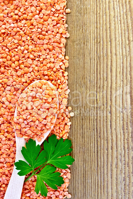 Lentils red with spoon and parsley on board