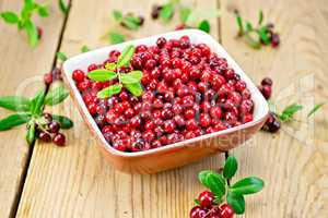 Lingonberry red in bowl on board