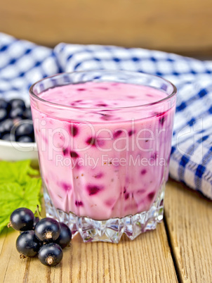 Milkshake with black currants in glass on board