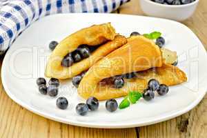 Pancakes with blueberries and napkin on board