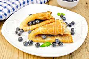 Pancakes with blueberries on wooden board