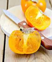 Persimmon with knife on board